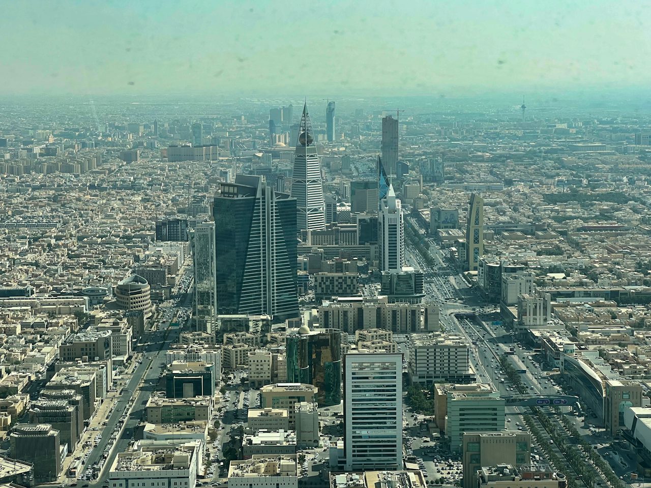 A wide boulevard between towers under a blue sky, Riyadh